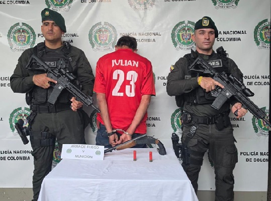 Dos policías y un Hombre capturado con arma de fuego y munición.