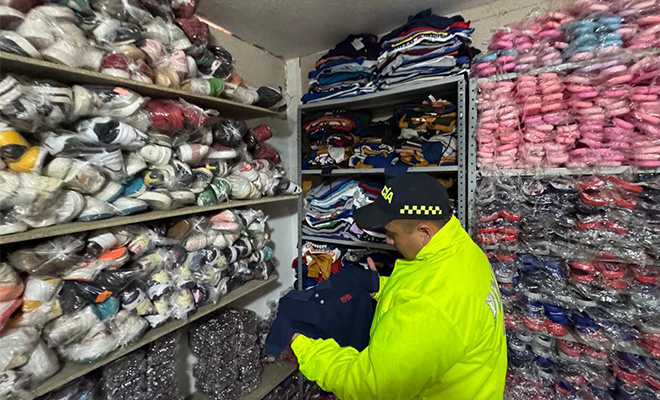 policia revisando mercanc&iacute;as decomisadas