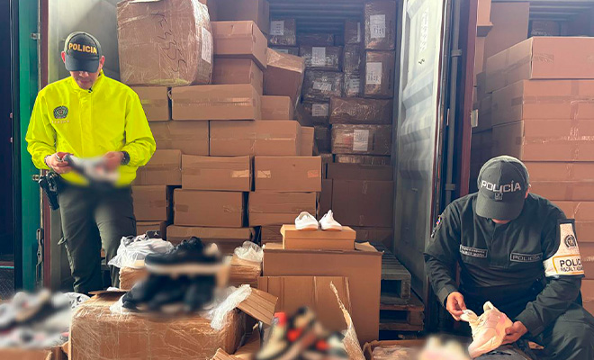 Dos policias revisando calzado decomisado