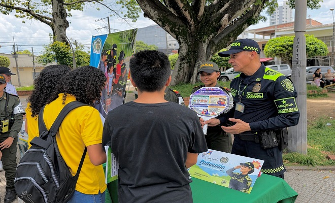un funcionario del grupo de Infancia y Adolescencia de la Policía Nacional brindando campaña de sensibilización sobre la protección de la niñez a 3 ciudadanos 