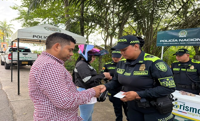 Uniformada de la Policía Nacional socializando las líneas de atención a un ciudadano 