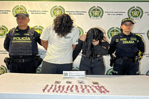 Dos uniformados custodian a dos personas capturadas y estupefacientes incautado