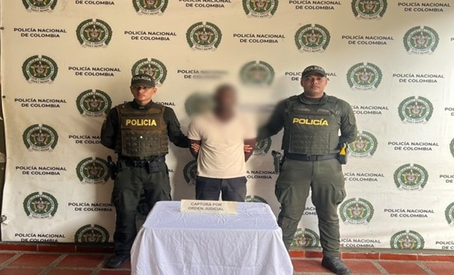 Dos uniformados de la Policía Nacional junto a una persona capturada durante un procedimiento por orden judicial en Quibdó.