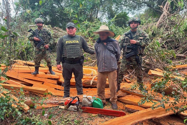 Un policía y dos soldados custodian a un hombre capturado