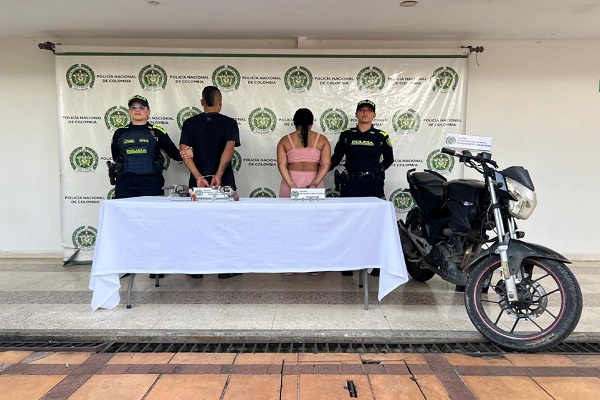 Dos Policías, dos capturados, una motocicleta incautada y mesa con dos armas de fuego incautadas
