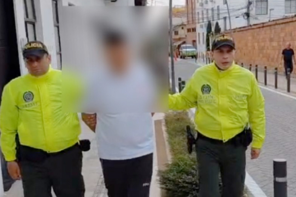Hombre capturado viste de camiseta blanca en medio de dos policías