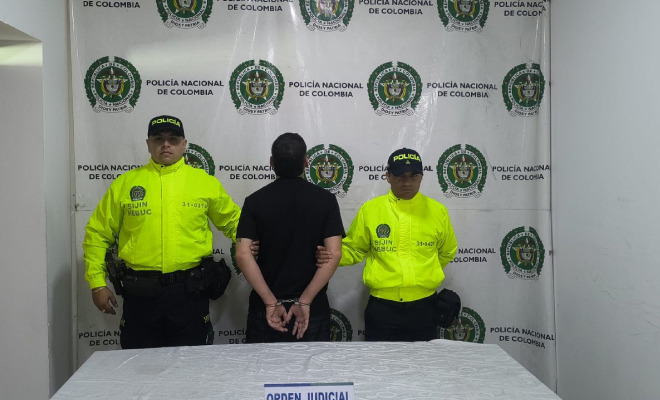 Hombre capturado en medio de dos Policías