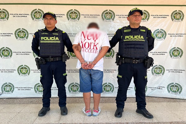 Dos funcionarios de la Policía Nacional junto a un hombre capturado