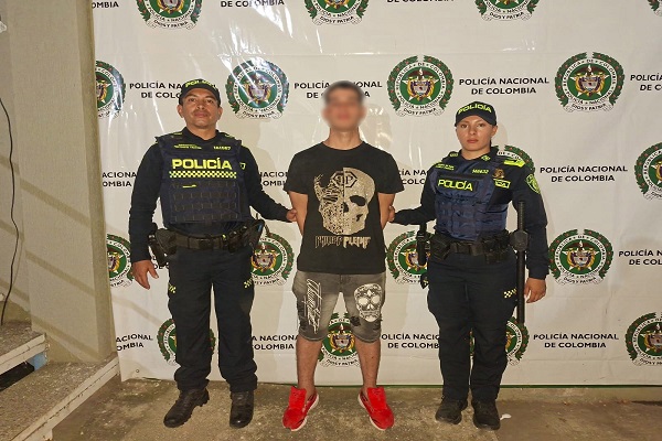 Dos policías custodian a un hombre capturado