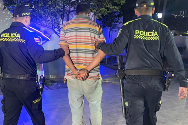 Hombre capturado con las manos esposadas en medio de dos policías