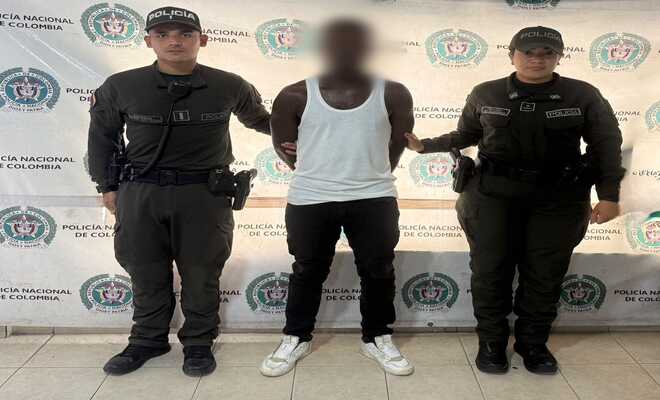 Un hombre capturado esposado con dos Policías en cada lado respectivamente 