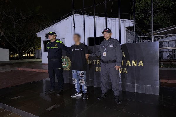 Dos polic&iacute;as custodian a un hombre capturado por orden judicial en Neiva