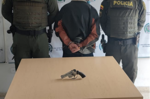 una persona capturada-policías custodiando-arma de fuego incautada