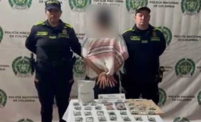Hombre capturado en medio de dos Policías, en frente elementos incautados