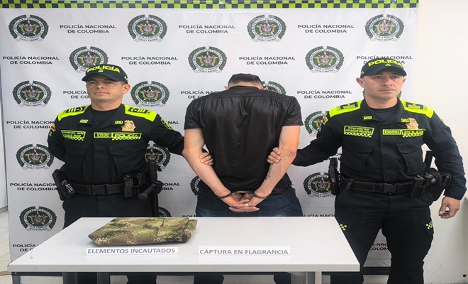 Dos policías con un capturado con uniforme institucional