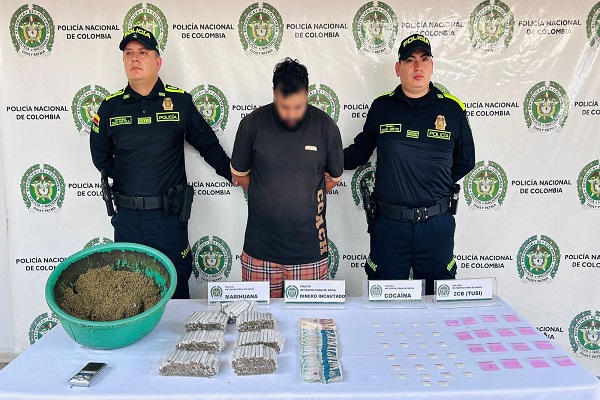 Dos Policías, un capturado, mesa con la incautación de estupefacientes