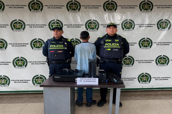 Dos Policías, un capturado y mesa con elementos recuperados