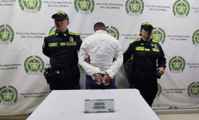 Hombre capturado en medio de dos Policías