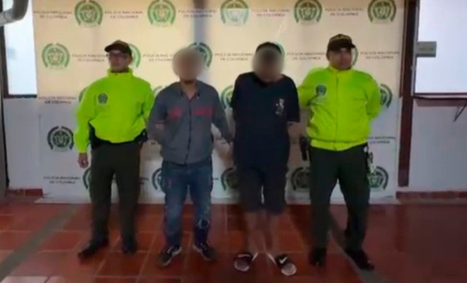 Hombres capturados en medio de dos Policías