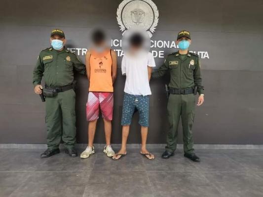 2 personas capturadas-policías custodiando