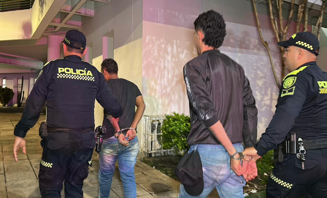 Hombres capturados en medio de dos Policías
