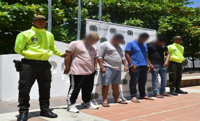 Personas capturadas-policías custodiando