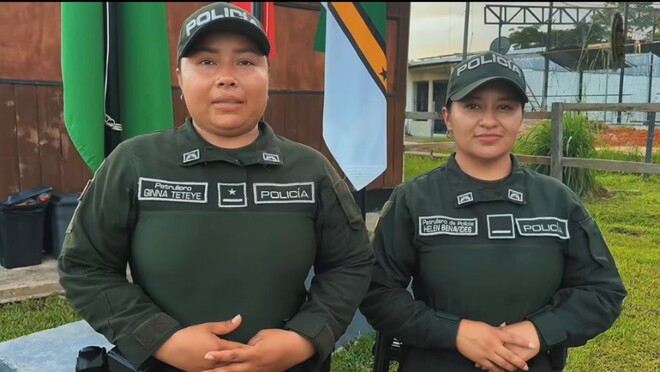 Dos mujeres con el uniforme verde de la Policía se encuentras mirando a la cámara dando a entender que dan una información