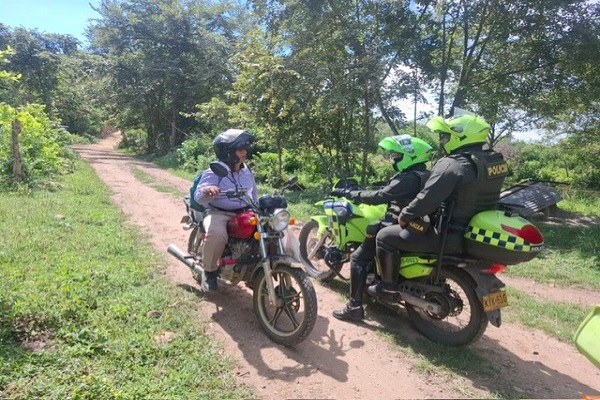 Dos Policías de carabineros en motocicleta saludando a ciudadano