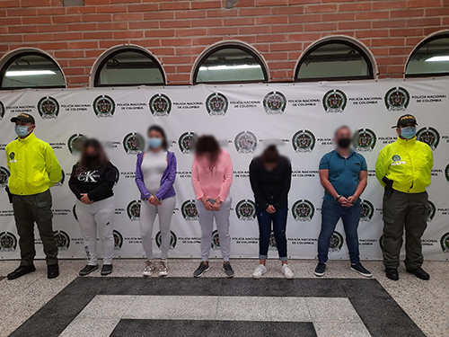Policías de la Sijin en Medellín custodian a capturados por narcotráfico