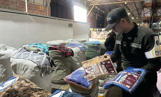Policía revisando confecciones de contrabando decomisadas