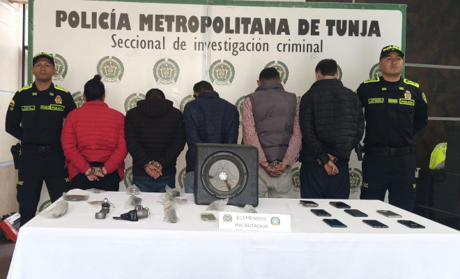 5 personas capturadas, en cada lado un policía y en la mesa elementos incautados