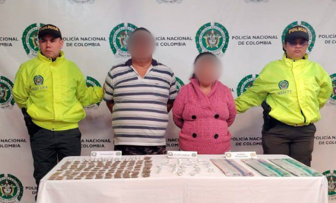 Personas capturadas en medio de dos Policías y elementos estupefacientes encima de una mesa