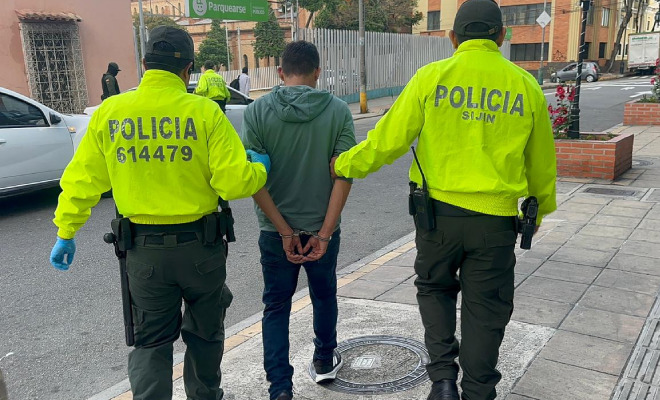 Hombre capturado en medio de dos Policías