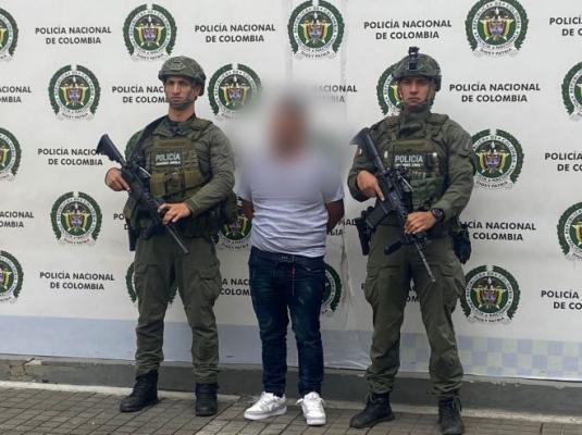 dos policías al lado de un hombre capturado
