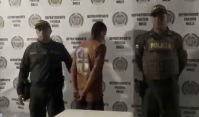 Dos polic&iacute;as al lado de un hombre capturado