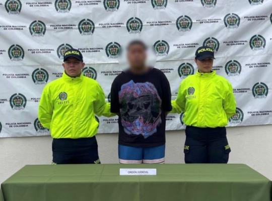 dos policías y en medio un hombre capturado  