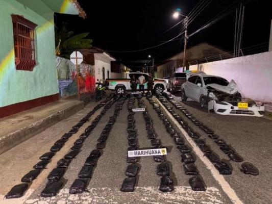 la policía nacional al lado de un hombre capturado con estupefacientes 
