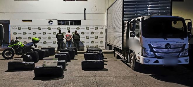 dos policías al lado de un hombre capturado con marihuana