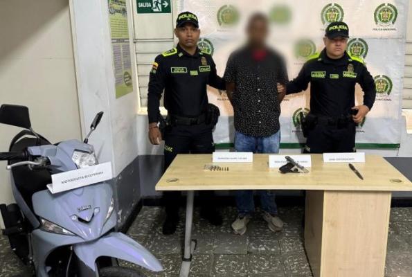 Dos policías al lado de un hombre capturado por hurto