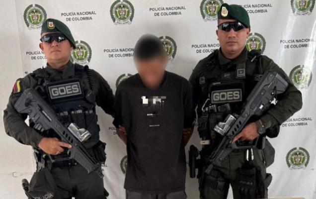Dos polic&iacute;as al lado de un hombre capturado por orden judicial