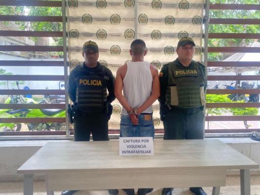 dos policías al lado de un hombre capturado por violencia intrafamiliar 
