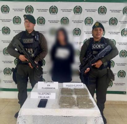 dos policías al lado de una mujer capturado con estupefacientes