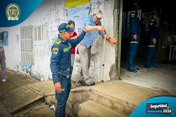 Uniformado de la Policía ayudan a un adulto mayor a ingresar al lugar