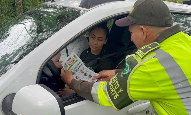Un polic&iacute;a de Transito y Transporte junto a un ciudadano, brindando recomendaciones.