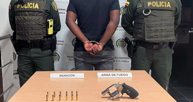Persona capturada- policías custodiando-arma de fuego-munición 