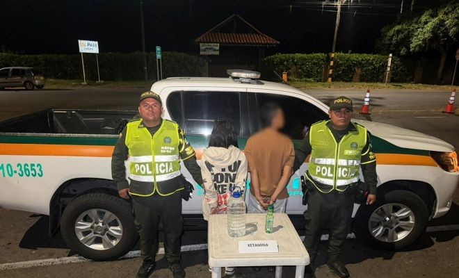 Dos capturados, dos policías y ketamina incautada, detrás se observa un vehículo de transito y transporte 