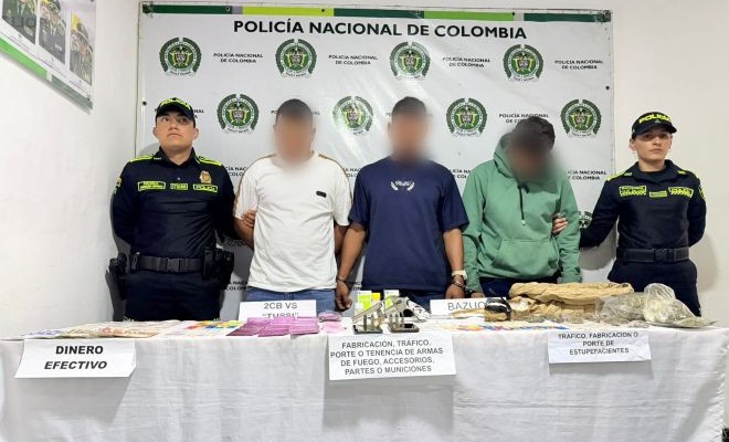 Dos policías, tres personas capturadas y elementos incautados encima de una mesa