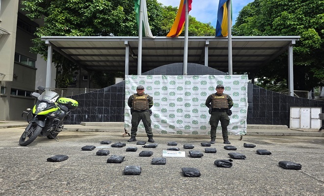 Dos funcionarios de la policía y 25 kilogramos de marihuana incautada.