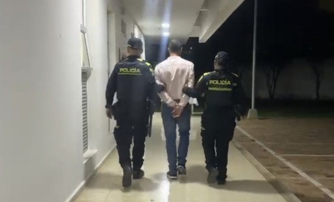 Hombre capturado en medio de dos Policías