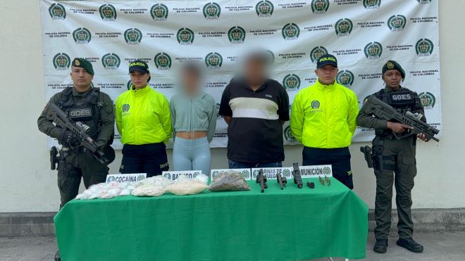 la policía nacional al lado de un hombre una mujer capturados con material incautado